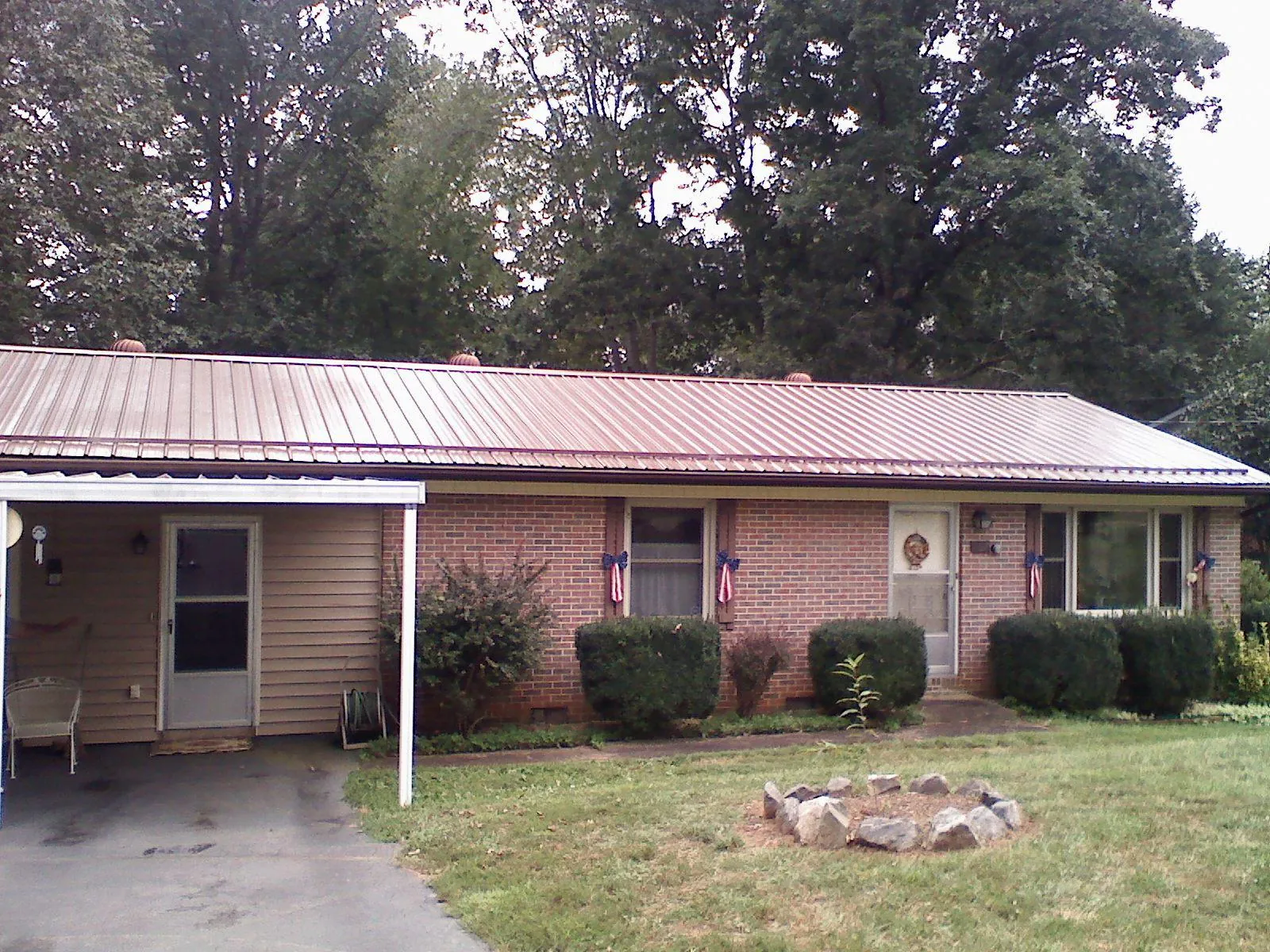 Bronze metal roof and carport on a brick ranch home — Roof Repair work by our crew in Independence