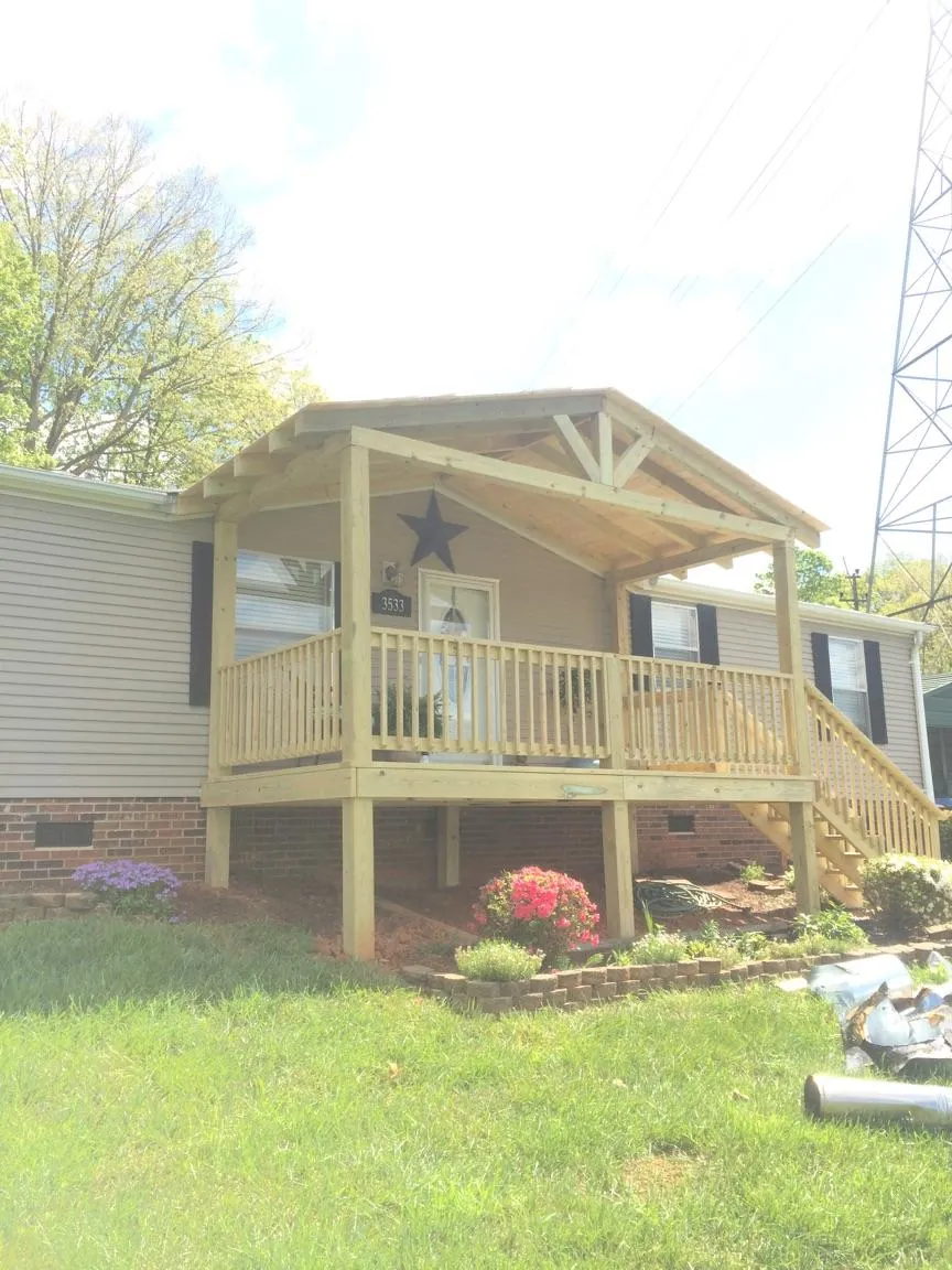 New gabled porch roof and deck railing added to a ranch home in Independence